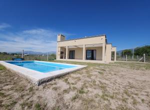 een huis met een zwembad ervoor bij El Rincón de Gemma in Salta