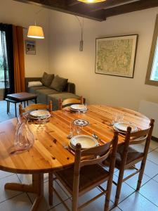 a wooden table with plates and wine glasses on it at Chalet D-LYS in Cauterets +13 photos
