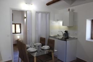 a kitchen and dining room with a table and a sink at L'ecureuil de luceram in Lucéram
