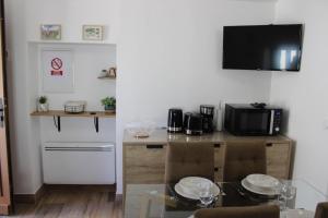 a kitchen with a table with chairs and a microwave at L'ecureuil de luceram in Lucéram