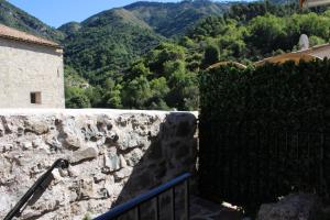a stone wall with a view of a mountain at L'ecureuil de luceram in Lucéram