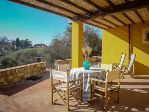 a table with chairs and a vase on a patio at Apartment With Terrace And Pool Near Lucca in San Quirico di Moriano