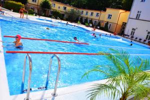 a large swimming pool with many people in it at Sanatorium Gryf in Połczyn-Zdrój