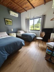 a bedroom with two beds and a window at La Recompensa House in Colonia Nuevo Paysandú