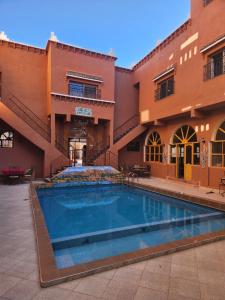 a pool in the courtyard of a building at La Rose De Sable in Aït Ben Haddou