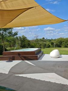 a wooden umbrella and a pool in a park at La Recompensa House in Colonia Nuevo Paysandú