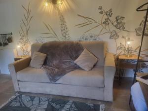 un sofá con una almohada en la sala de estar en L'ombre du vent, en Contes