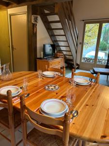 a wooden table with plates and glasses on it at Chalet D-LYS in Cauterets