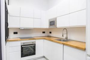 a white kitchen with white cabinets and a sink at NOMADIA en Plaza de la Constitucion 1 in Málaga