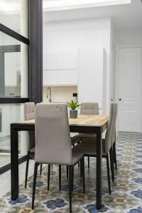 a dining room with a wooden table and chairs at NOMADIA en Plaza de la Constitucion 1 in Málaga