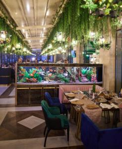 een restaurant met tafels en stoelen en een groot aquarium bij Central Address Studio 16 in Boekarest