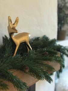 Ein Miniatur-Rentier aus Gold an einem Weihnachtsbaumzweig in der Unterkunft Beautiful Cottage nr Mendip Hills Private Parking in Chilcompton