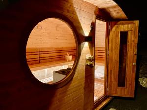 a circular mirror on the side of a sauna at Traumferienwohnung Alpenliebe Sommer-Hörnerbahnen kostenlos in Bolsterlang +36 photos