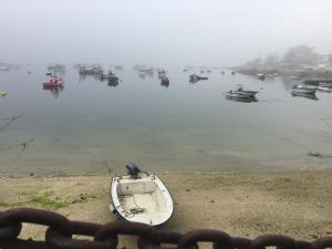 un barco sentado en el agua en la niebla en Apartamento Alvaro, en A Illa de Arousa