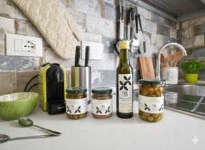 a kitchen counter with bottles of wine and jars of olives at Maddalena Holiday House in Imperia +5 photos