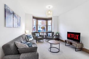 ベッドフォードにあるLuxeVille I Serene 3BR Apartment with Private Courtyard I LongTerm RatesI ParkingI WiFiのソファとテレビのあるリビングルーム