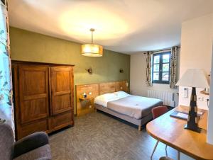 een slaapkamer met een bed, een bureau en een tafel bij Hôtel Le Quatorze in Figeac