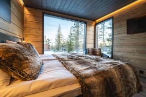 a bedroom with a large bed with a large window at Aurora Hill Resort, Rovaniemi in Rovaniemi