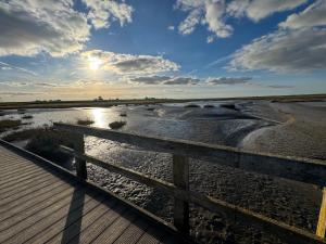 a view of a beach with a wooden fence at Ferienwohnung Reede 19 in Butjadingen