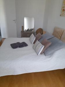 a large white bed with pillows on top of it at Perigueux T2 proche du quartier historique in Périgueux