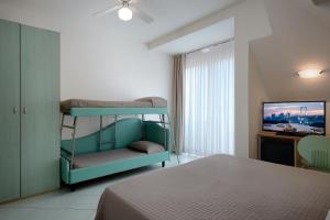 a bedroom with a bunk bed and a flat screen tv at Hotel Romagna in Cattolica