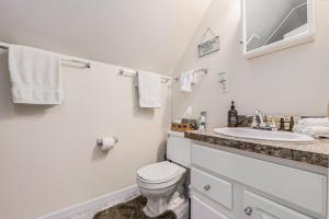 a white bathroom with a toilet and a sink at Relax & Explore Waterfront Crawford Lake Cottage 4878 in Darragh