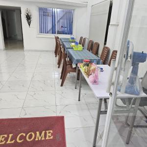 une salle à manger avec une longue table et des chaises dans l'établissement Indian Valley Guest House, à Sihanoukville