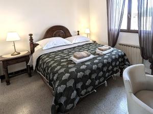 ein Schlafzimmer mit einem Bett mit einer schwarz-weißen Bettdecke in der Unterkunft LE CHESTER - Maison de charme en Provence avec piscine près de L'Isle-sur-la-Sorgue in Velleron