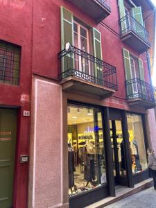 a red building with two balconies and a store at Casa Malvina in Intra