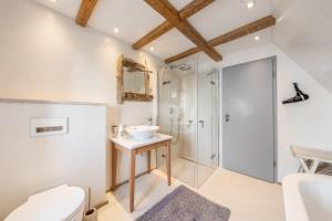 a bathroom with a toilet and a sink and a shower at Lighthouse 2 in Hörnum +30 photos