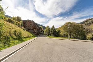 een lege weg met een gebouw aan de zijkant van een heuvel bij A Cozy Refuge - 2min drive to slopes - 4pax in Soldeu +52 foto's