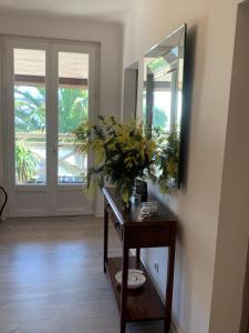 a room with a mirror and a table with flowers at Hôtel La Cote d'Argent in Seignosse