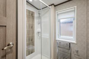 une salle de bain avec douche et porte vitrée dans l'établissement Brackencroft Lodge with Hot Tub, à York 33 autres photos