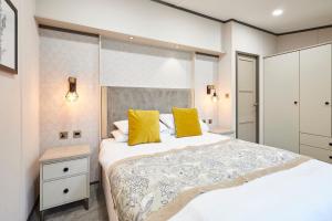 une chambre avec un grand lit avec des oreillers jaunes dans l'établissement Brackencroft Lodge with Hot Tub, à York