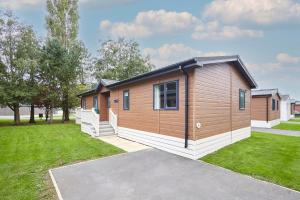 une grande cabane en bois avec une cour herbeuse dans l'établissement Brackencroft Lodge with Hot Tub, à York