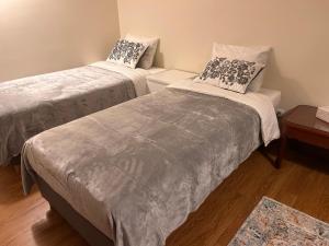 une chambre avec deux lits et une table dans l'établissement Maia Oporto Suites, à Maia