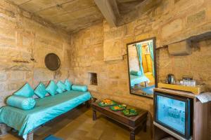 uma sala de estar com um sofá e uma TV em Hotel Rajmandir em Jaisalmer