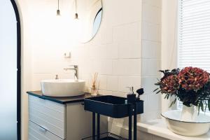a bathroom with a sink and a mirror and flowers at Ubytování Javorka in Česká Třebová +25 photos