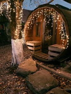 a cabin with christmas lights around a tree at Equestrian Center Farm House in Mereni +13 photos