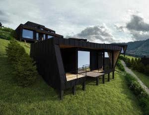 a black house on top of a green field at Emshir Villas in Krasnik