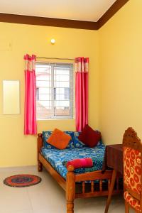 a bedroom with a bed with red curtains and a window at Gardenia Inn in Madikeri