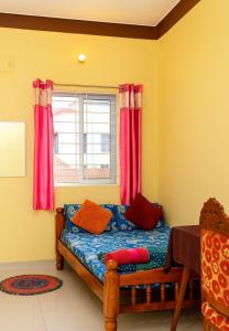 a bedroom with a bed with red curtains and a window at Gardenia Inn in Madikeri