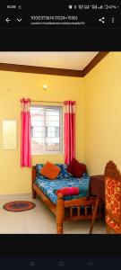 a bedroom with a bed and a window with red curtains at Gardenia Inn in Madikeri +9 photos