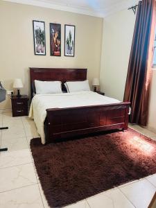 Un dormitorio con una cama grande y una alfombra. en Zuri home 2, en Kampala
