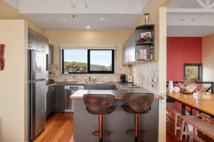 eine Küche mit einer großen Insel mit zwei Barhockern in der Unterkunft Amazing Views in Surf Beach