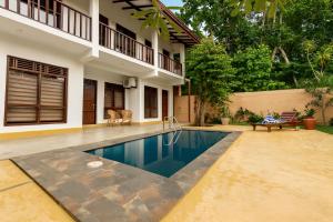 a swimming pool in front of a house at Bentota Luxe Ayurveda in Bentota