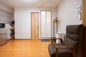 a living room with a chair and a door at Just a short walk 心斎橋 Glico Sign 1min 道頓堀30-second 黒門市場 難波駅 Dotonbori Guesthouse 松の阁 in Osaka +55 photos