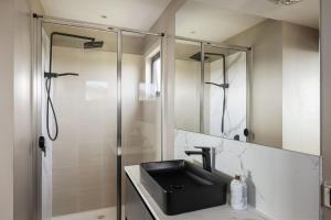 ein Badezimmer mit Waschbecken und Dusche in der Unterkunft Amazing Views in Surf Beach + 12 Fotos