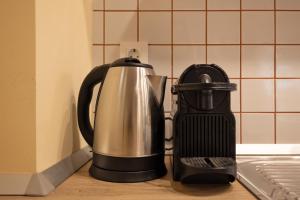 affeepot and coffee maker sitting on a kitchen counter at Apartment Arc 23 in Celje +10 photos