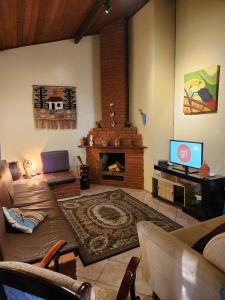 a living room with a couch and a fireplace at Refúgio com Piscina, Churrasco e Lazer no Campo in Sumaré